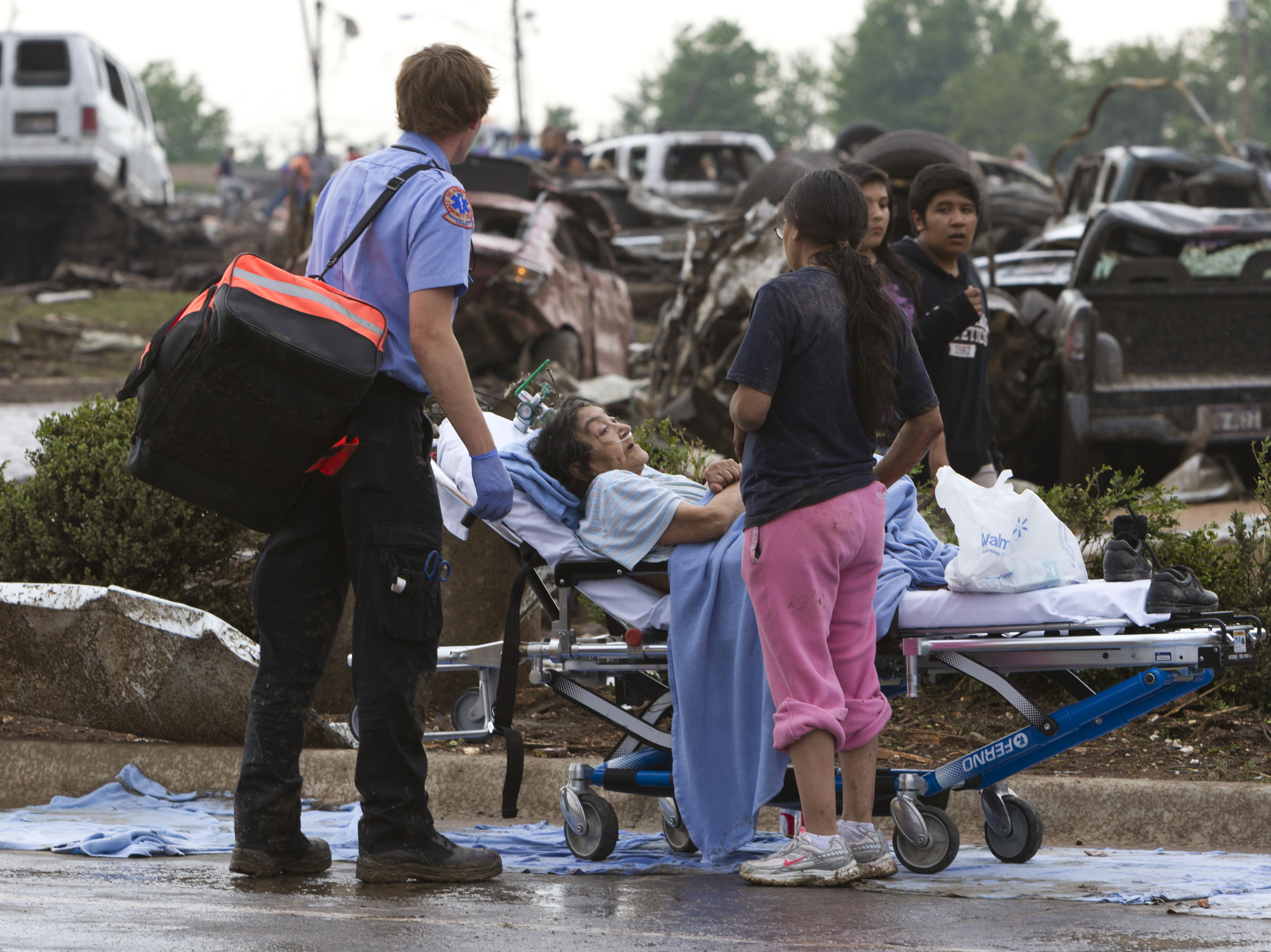 A Moore Medical Center patient sits in the parking lot after a tornado damaged the hospital on Monday.