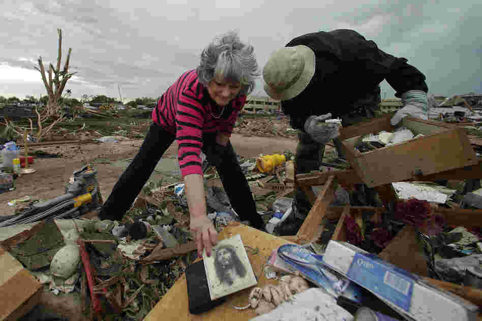 Lea Bessinger salvages a picture of Jesus as she and her son Josh Bessinger sort through the rubble of her home in Moore.