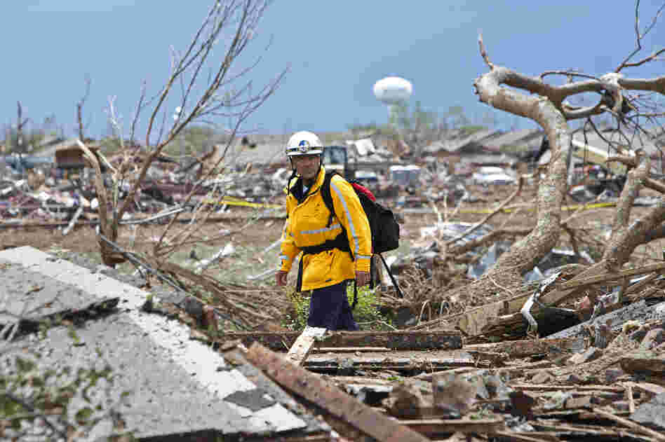 A rescue worker checks the rubble in a residential area in Moore, Okla., on Tuesday after a massive tornado struck the area on Monday. Emergency workers pulled more than 100 survivors from the rubble of homes, schools and a hospital in Moore.