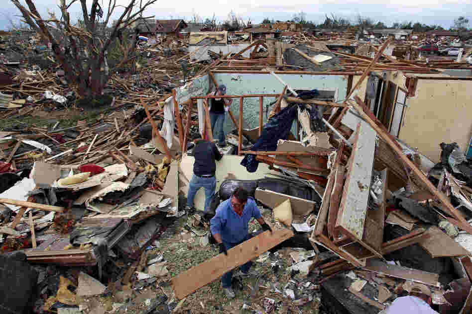 Jimmy Hodges helps Chad Heltcel and his wife Cassidi salvage the wreckage of Chad Heltcel's family home on Tuesday, which was destroyed Monday when a tornado moved through Moore, Okla. The National Weather Service now , this tornado produced winds in excess of 200 mph, making it a top-of-the-scale EF-5.