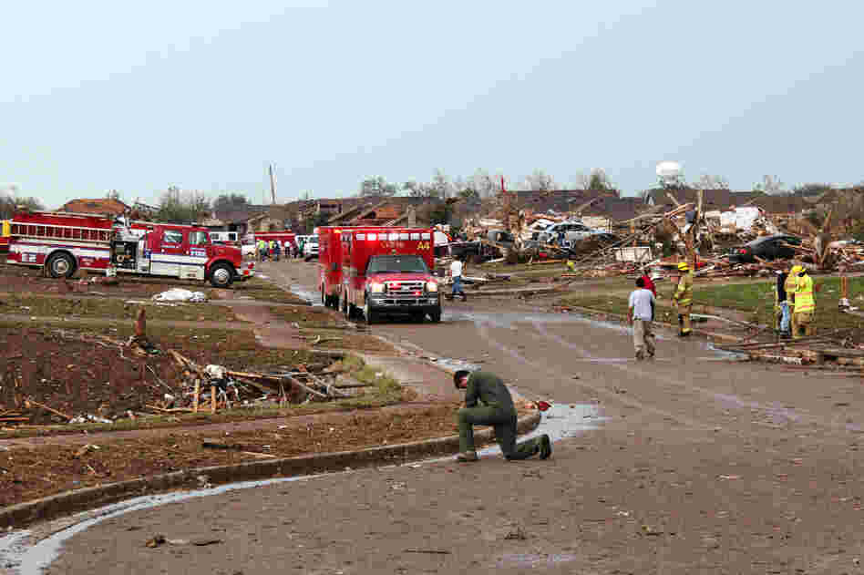 An airman kneels and prays in the Moore neighborhood south of Plaza Towers Elementary School.