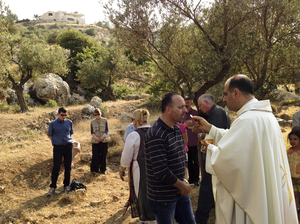 Ibrahim Shomali, a Palestinian priest, offers Communion under the olive trees of the Cremisan Valley in the Israeli-occupied West Bank. This is part of a regular protest against Israeli plans to build a section of its West Bank barrier here, which would separate Palestinians from their agricultural lands. Ibrahim Shomali, a Palestinian priest, offers Communion under the olive trees of the Cremisan Valley in the Israeli-occupied West Bank. This is part of a regular protest against Israeli plans to build a section of its West Bank barrier here, which would separate Palestinians from their agricultural lands.