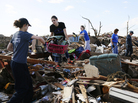 Volunteers form a chain as they retrieve clothing and other household items at a home destroyed by a tornado, across the street from Plaza Towers Elementary School in Moore, Okla., on Wednesday. Volunteers form a chain as they retrieve clothing and other household items at a home destroyed by a tornado, across the street from Plaza Towers Elementary School in Moore, Okla., on Wednesday.