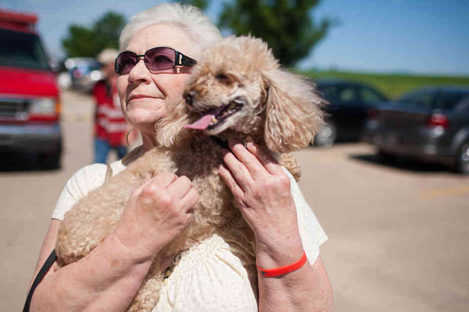 Marylin Degman holds her 10-year-old toy poodle, Angel Baby, on Wednesday outside the First Baptist Church in Moore, Okla.