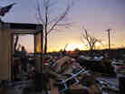 Rita Green carried a plastic bin of items as she helped a family friend salvage things from a home Thursday in Moore, Okla.