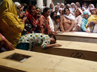 A relative of one of the children who died after a fire on a school bus, cries over the coffin, on the outskirts of Gujrat. A relative of one of the children who died after a fire on a school bus, cries over the coffin, on the outskirts of Gujrat.