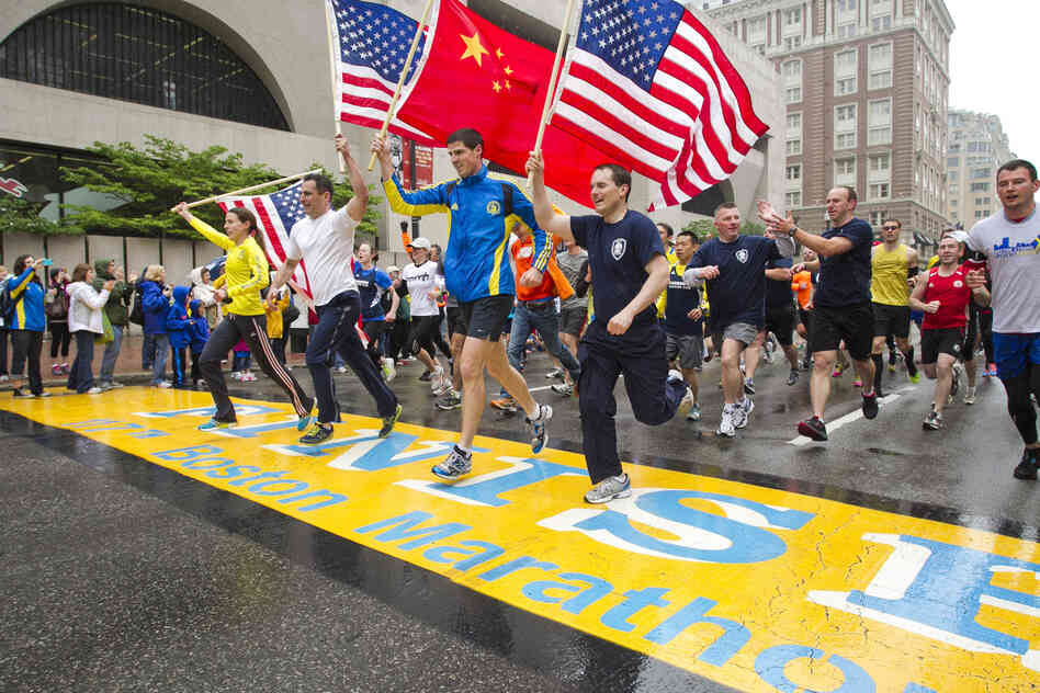 Runners holding American flags and a Chinese flag cross the finish line after completing the final mile of the Boston Marathon course during "#onerun" in Boston, Massachusetts on Saturday. Runners holding American flags and a Chinese flag cross the finish line after completing the final mile of the Boston Marathon course during "#onerun" in Boston, Massachusetts on Saturday.