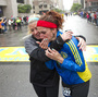 Erin Roy, left, comforts Elise Wulff as runners cross the finish line after completing the final mile of the Boston Marathon course during "#onerun" in Boston, Massachusetts, on Saturday.