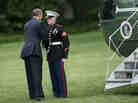 President Obama greets a Marine after forgetting to salute him while boarding Marine One on the South Lawn of the White House.