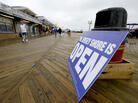People walk on the boardwalk in Seaside Heights, N.J., on Friday. The Jersey Shore beaches officially opened for the summer, after rebuilding following the destruction left behind by Superstorm Sandy last fall. The storm caused $37 billion of damage in the state. People walk on the boardwalk in Seaside Heights, N.J., on Friday. The Jersey Shore beaches officially opened for the summer, after rebuilding following the destruction left behind by Superstorm Sandy last fall. The storm caused $37 billion of damage in the state.