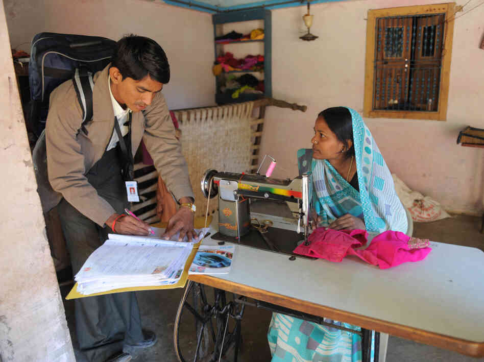 An official from a microfinance company talks with a borrower in Vadod, India. An official from a microfinance company talks with a borrower in Vadod, India.