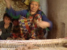 In Oqa, Afghanistan, Boston weaves a saddlebag for her husband's donkey. The weavers of Oqa also weave large carpets, earning less than $1 a day for their work. In Oqa, Afghanistan, Boston weaves a saddlebag for her husband's donkey. The weavers of Oqa also weave large carpets, earning less than $1 a day for their work.