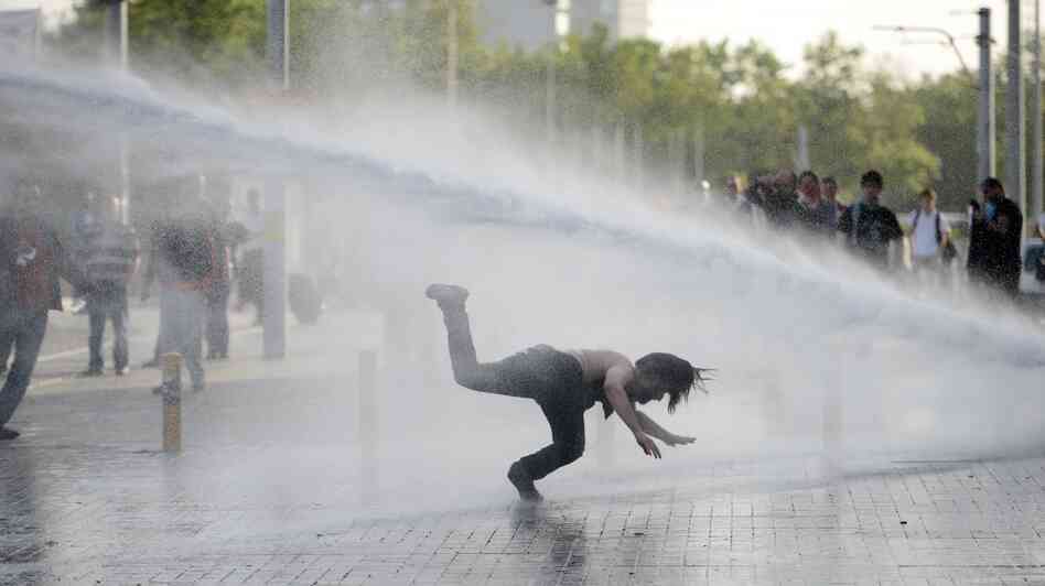 Demonstrators flee from a water cannon during clashes with riot police Friday during a protest against the demolition of Taksim Gezi Park, in Taksim Square in Istanbul. Demonstrators flee from a water cannon during clashes with riot police Friday during a protest against the demolition of Taksim Gezi Park, in Taksim Square in Istanbul.