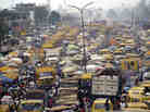 People walk struggling for space between public transport buses and trucks at the burstling Oshodi bus stop in Lagos 06 February 2006. Lagos is reputed as one of the mostly densely populated city in the world with population more than 14 million. AFP PHOTO/PIUS UTOMI EKPEI (Photo credit should read PIUS UTOMI EKPEI/AFP/Getty Images)