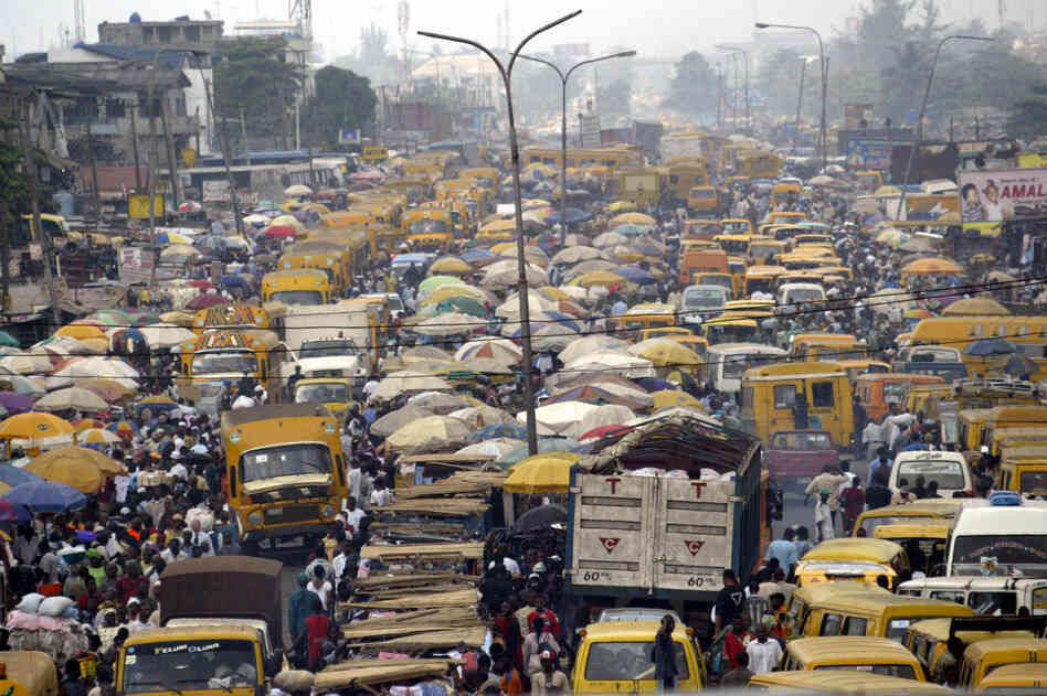 People walk struggling for space between public transport buses and trucks at the burstling Oshodi bus stop in Lagos 06 February 2006. Lagos is reputed as one of the mostly densely populated city in the world with population more than 14 million. AFP PHOTO/PIUS UTOMI EKPEI (Photo credit should read PIUS UTOMI EKPEI/AFP/Getty Images) People walk struggling for space between public transport buses and trucks at the burstling Oshodi bus stop in Lagos 06 February 2006. Lagos is reputed as one of the mostly densely populated city in the world with population more than 14 million. AFP PHOTO/PIUS UTOMI EKPEI (Photo credit should read PIUS UTOMI EKPEI/AFP/Getty Images)