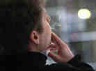 A man smokes outside an office building in New York City in April. Smoking breaks cost employers almost $3,000 per year per smoking employees, a study says.