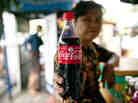 A street vendor holds up a Coca-Cola bottle in Yangon, Myanmar. A street vendor holds up a Coca-Cola bottle in Yangon, Myanmar.