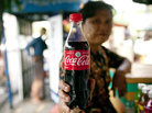 A street vendor holds up a Coca-Cola bottle in Yangon, Myanmar. A street vendor holds up a Coca-Cola bottle in Yangon, Myanmar.