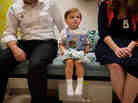 Barton Holmes, 2, sits with his father, Kevin Holmes, and his mother, Catherine McEaddy Holmes, during an appointment at Children's National Medical Center in Washington, D.C.