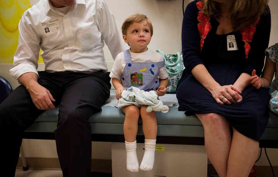 Barton Holmes, 2, sits with his father, Kevin Holmes, and his mother, Catherine McEaddy Holmes, during an appointment at Children's National Medical Center in Washington, D.C. Barton Holmes, 2, sits with his father, Kevin Holmes, and his mother, Catherine McEaddy Holmes, during an appointment at Children's National Medical Center in Washington, D.C.
