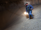 Grain Operator Austin Clubb surveys corn inside the Homestead Grain Facility at Amana Farms near Cedar Rapids, Iowa. Grain Operator Austin Clubb surveys corn inside the Homestead Grain Facility at Amana Farms near Cedar Rapids, Iowa.