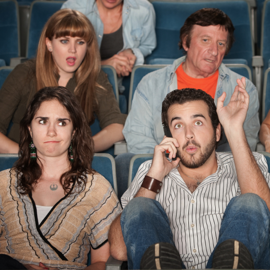 Man on the phone in a theater.