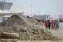 As Sochi, Russia, prepares to host the 2014 Olympic Games, workers walk past piles of dirt at the construction site of Fisht Stadium and Olympic Park on May 20.