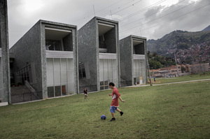 Boys play soccer in front of one of the new schools built by the city to improve the troubled Comuna 13 district.