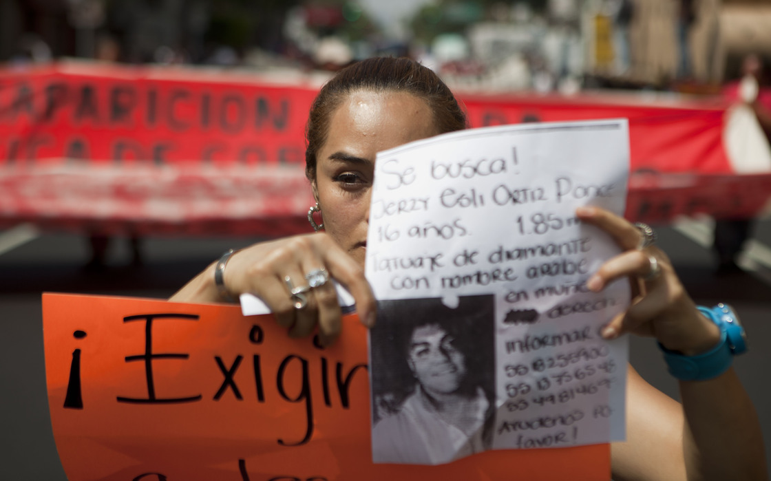 A woman holds up a sign with details of her recently disappeared relative during a protest in Mexico City, on May 30.