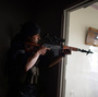 A Syrian rebel aims his sniper rifle at Syrian government forces in the Sheikh Maqsud district of Aleppo, in April.