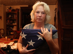 Anna holds the flag that was draped over Nick's coffin at his memorial service. She and her husband, Michael, have created a shrine to Nick in their dining room. Anna holds the flag that was draped over Nick's coffin at his memorial service. She and her husband, Michael, have created a shrine to Nick in their dining room.