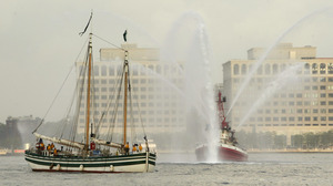 The Lois McClure (left) passes a fire boat as it arrives at New York's North Cove Marina in 2005. Canal schooners used wind power on open lakes, and lowered their masts and raised their centerboards to be towed through canals.