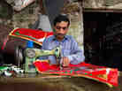 A young man stitches decorative seat covers and curtains in Rawalpindi, where he works for more than 12 hours a day.