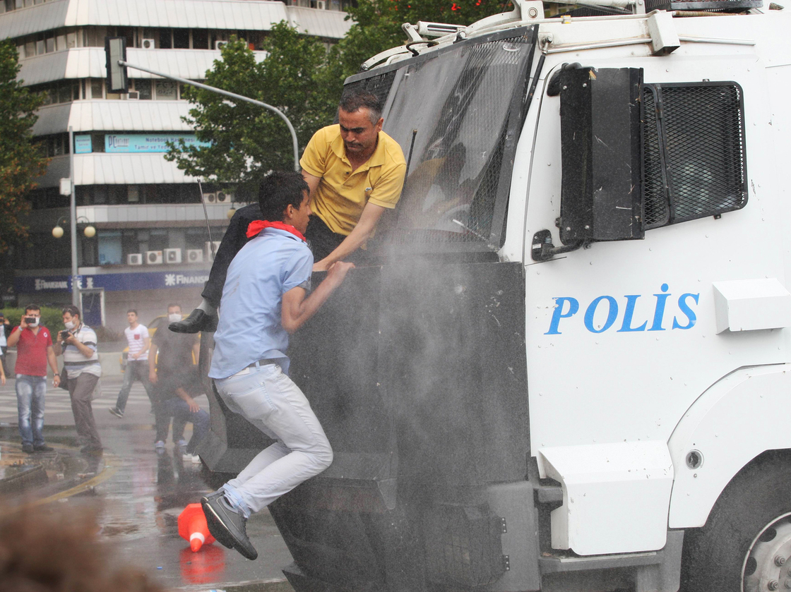 Protesters climb onto a police truck mounted with a water cannon during clashes with riot police at a demonstration in Ankara on Sunday.