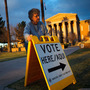 Election Day volunteer Vicki Groff places a sign to direct voters to a polling station at Kenilworth School in Phoenix in 2012.