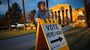Election Day volunteer Vicki Groff places a sign to direct voters to a polling station at Kenilworth School in Phoenix in 2012.