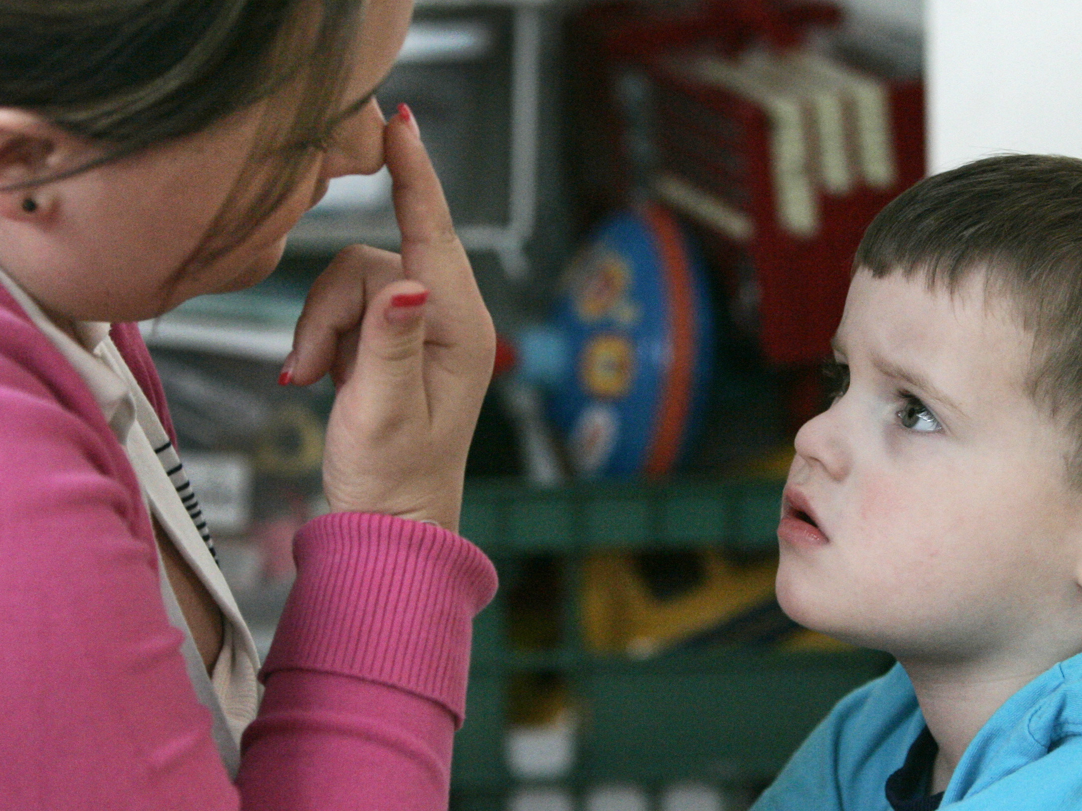 Instructional assistant Jessica Reeder touches her nose to get Jacob Day, 3, who has autism, to focus his attention on her during a therapy session in April 2007.