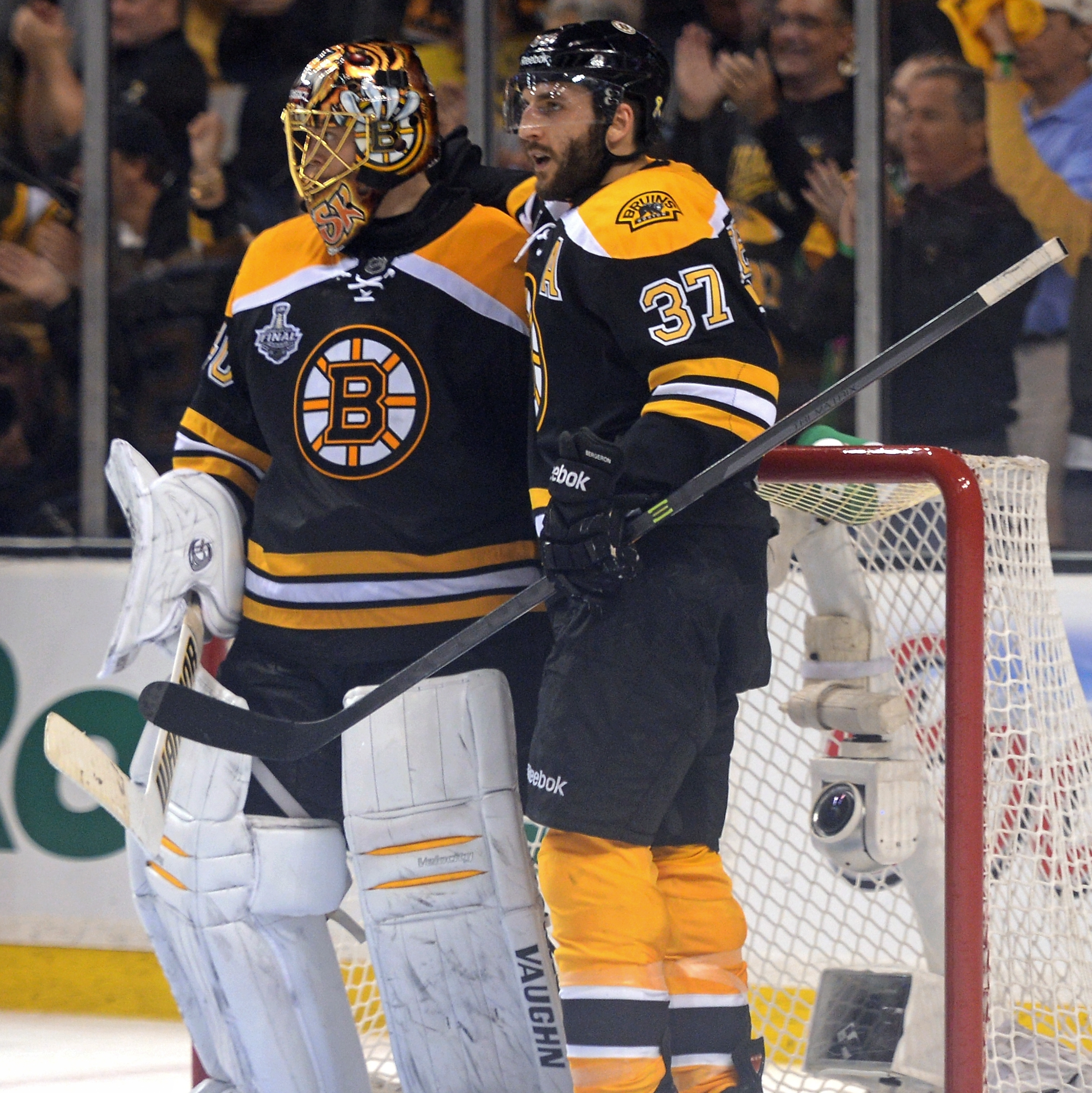 Patrice Bergeron #37 of the Boston Bruins celebrates with Tuukka Rask #40 after defeating the Chicago Blackhawks 2-0 in Game 3 of the NHL Stanley Cup Final at TD Garden Monday night in Boston.