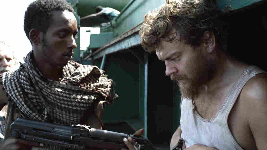 Pilou Asbaek (right) plays ship's cook Mikkel, a new dad who desperately wishes to return to his family, but is instead forced to prepare menus at gunpoint as the cargo vessel's owners negotiate for its release. Pilou Asbaek (right) plays ship's cook Mikkel, a new dad who desperately wishes to return to his family, but is instead forced to prepare menus at gunpoint as the cargo vessel's owners negotiate for its release.
