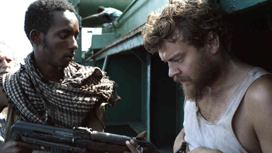Pilou Asbaek (right) plays ship's cook Mikkel, a new dad who desperately wishes to return to his family, but is instead forced to prepare menus at gunpoint as the cargo vessel's owners negotiate for its release. Pilou Asbaek (right) plays ship's cook Mikkel, a new dad who desperately wishes to return to his family, but is instead forced to prepare menus at gunpoint as the cargo vessel's owners negotiate for its release.