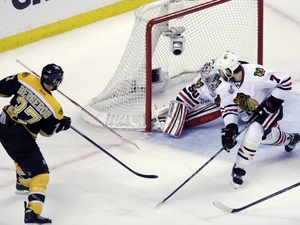 Boston Bruins center Patrice Bergeron (37) sends the puck past Chicago Blackhawks goalie Corey Crawford on Monday night. Boston Bruins center Patrice Bergeron (37) sends the puck past Chicago Blackhawks goalie Corey Crawford on Monday night.