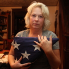 Anna holds the flag that was draped over Nick's coffin at his memorial service. She and her husband, Michael, have created a shrine to Nick in their dining room. Anna holds the flag that was draped over Nick's coffin at his memorial service. She and her husband, Michael, have created a shrine to Nick in their dining room.