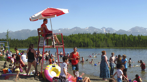 In this photo taken on Monday, people swim and sunbathe at Goose Lake in Anchorage, Alaska.