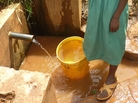Rodan Gatia gets water from a spring. A chlorine dispenser is behind her. Rodan Gatia gets water from a spring. A chlorine dispenser is behind her.