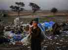 Afghan refugee children collect items of use from a pile of garbage on the outskirts of Islamabad, Pakistan.