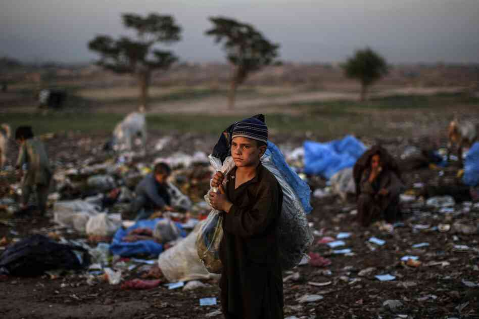 Afghan refugee children collect items of use from a pile of garbage on the outskirts of Islamabad, Pakistan. Afghan refugee children collect items of use from a pile of garbage on the outskirts of Islamabad, Pakistan.