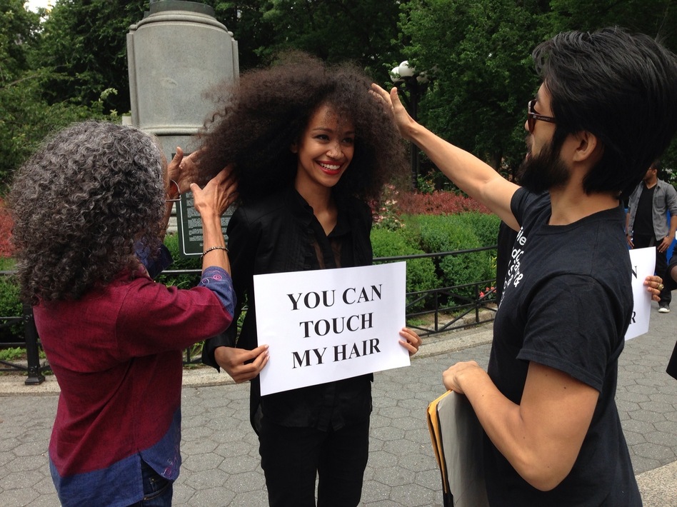 Model Malliha Ahmad holds a sign inviting passersby to touch her hair.