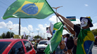 A protester waves a Brazilian flag over cars driving to the football stadium in Fortaleza, Northern Brazil, on June 19, 2013. A protester waves a Brazilian flag over cars driving to the football stadium in Fortaleza, Northern Brazil, on June 19, 2013.