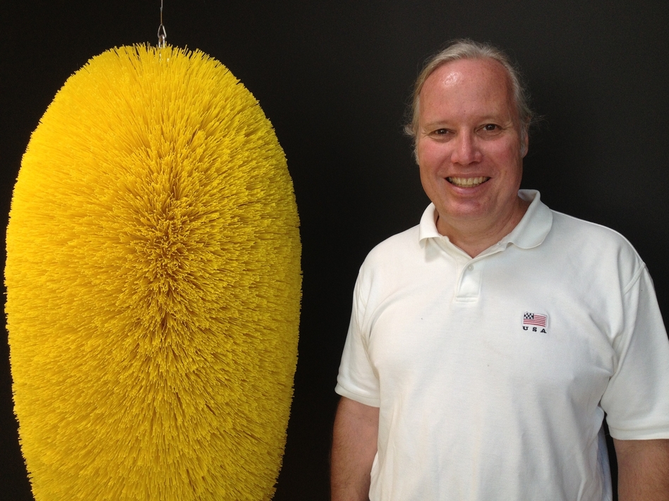 Fourth-generation owner of Braun Brush, Lance Cheney, stands next to a special-order brush his company made for the artist Richard Artschwager.