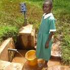 Rodan Gatia gets water from a spring. A chlorine dispenser is behind her.